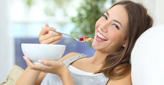 Woman eating a healthy breakfast in her couch. 